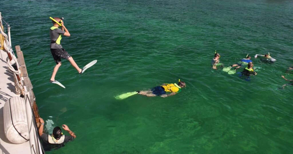 Snorkelers jumping from Ciganka